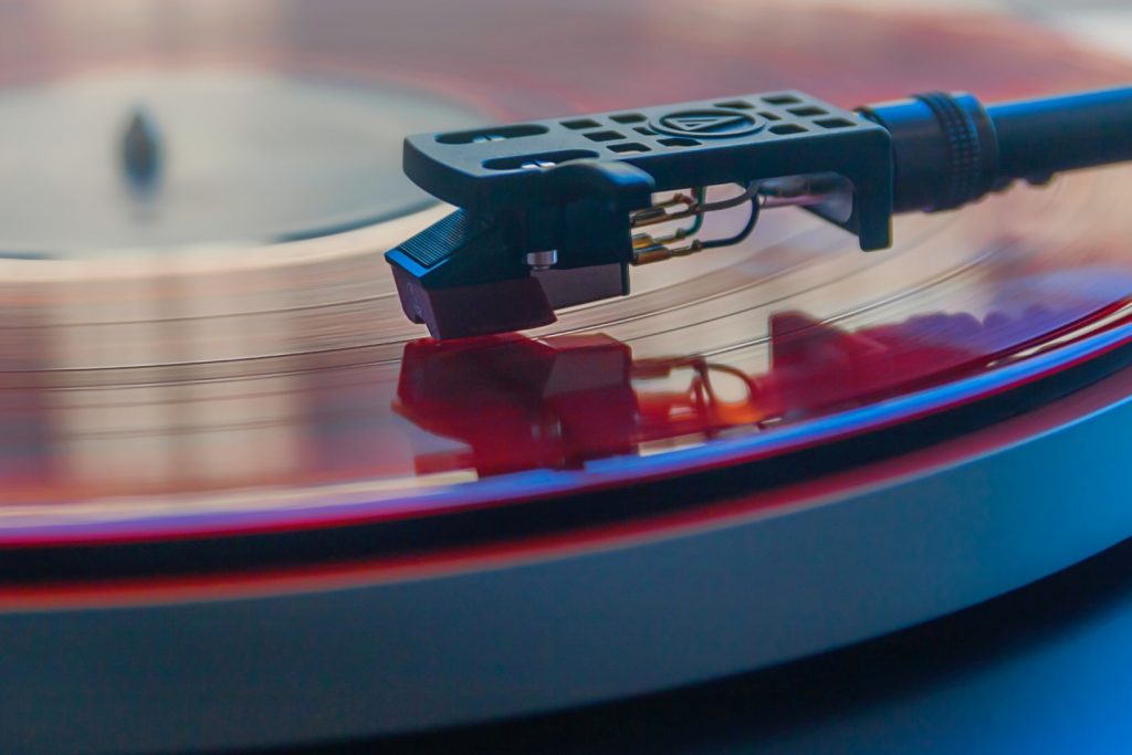 Closeup photograph of a tone arm on a spinning LP record