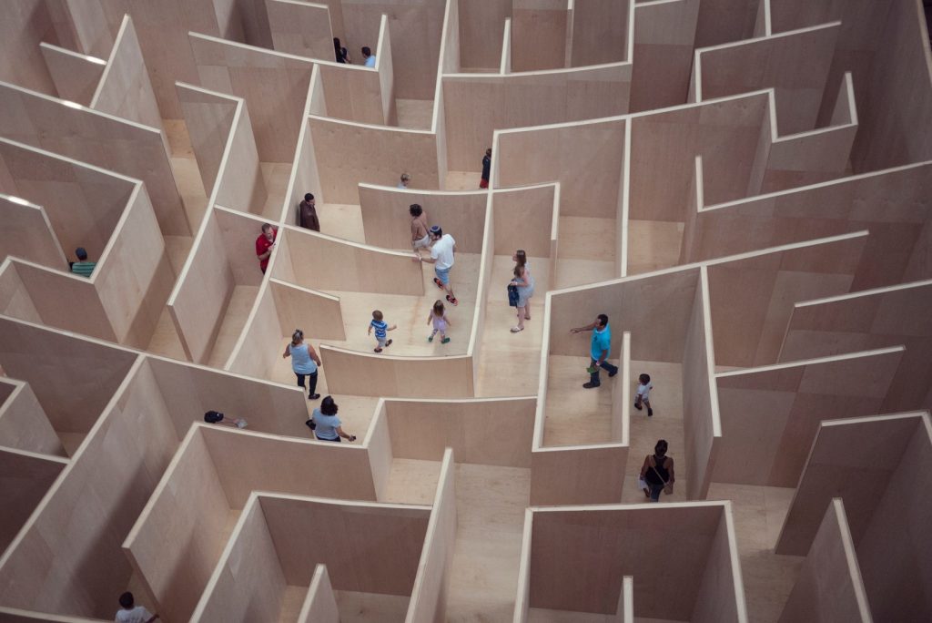 People walking in an elaborate maze, viewed from above.
