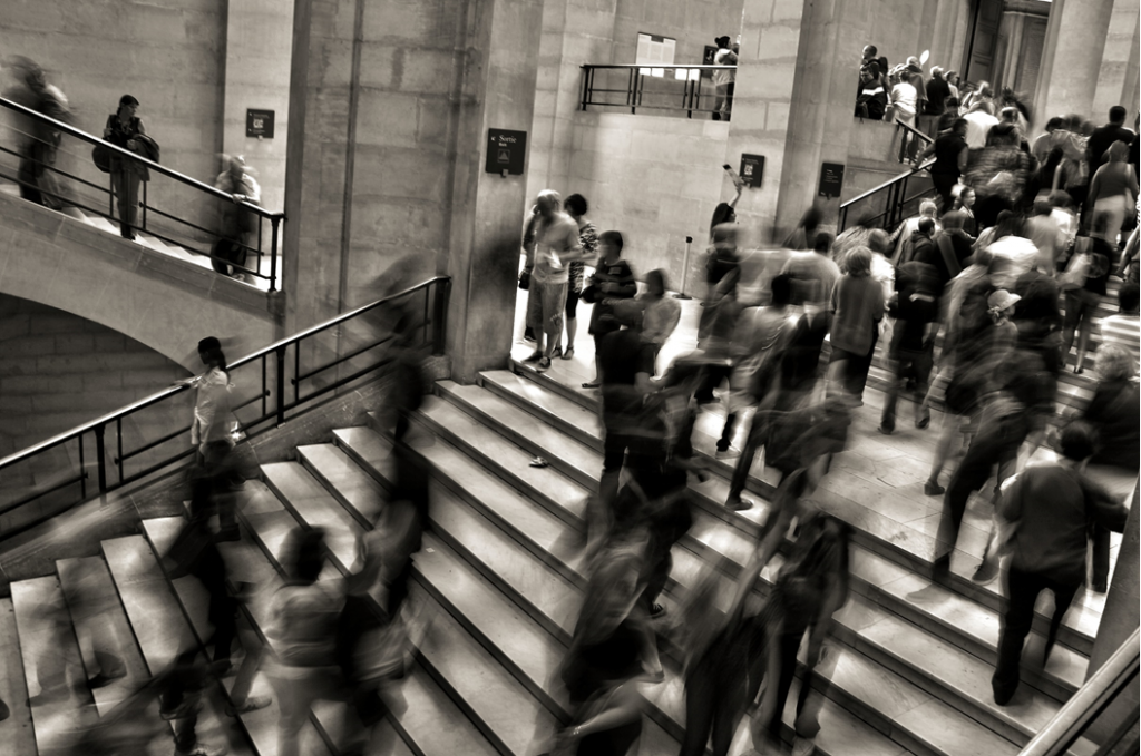 High-angle, motion-blurred exposure of a crowd of people going up and down a broad stairway in a public area, such as a train or metro station. Image credit: José Martín Ramírez Carrasco/Unsplash