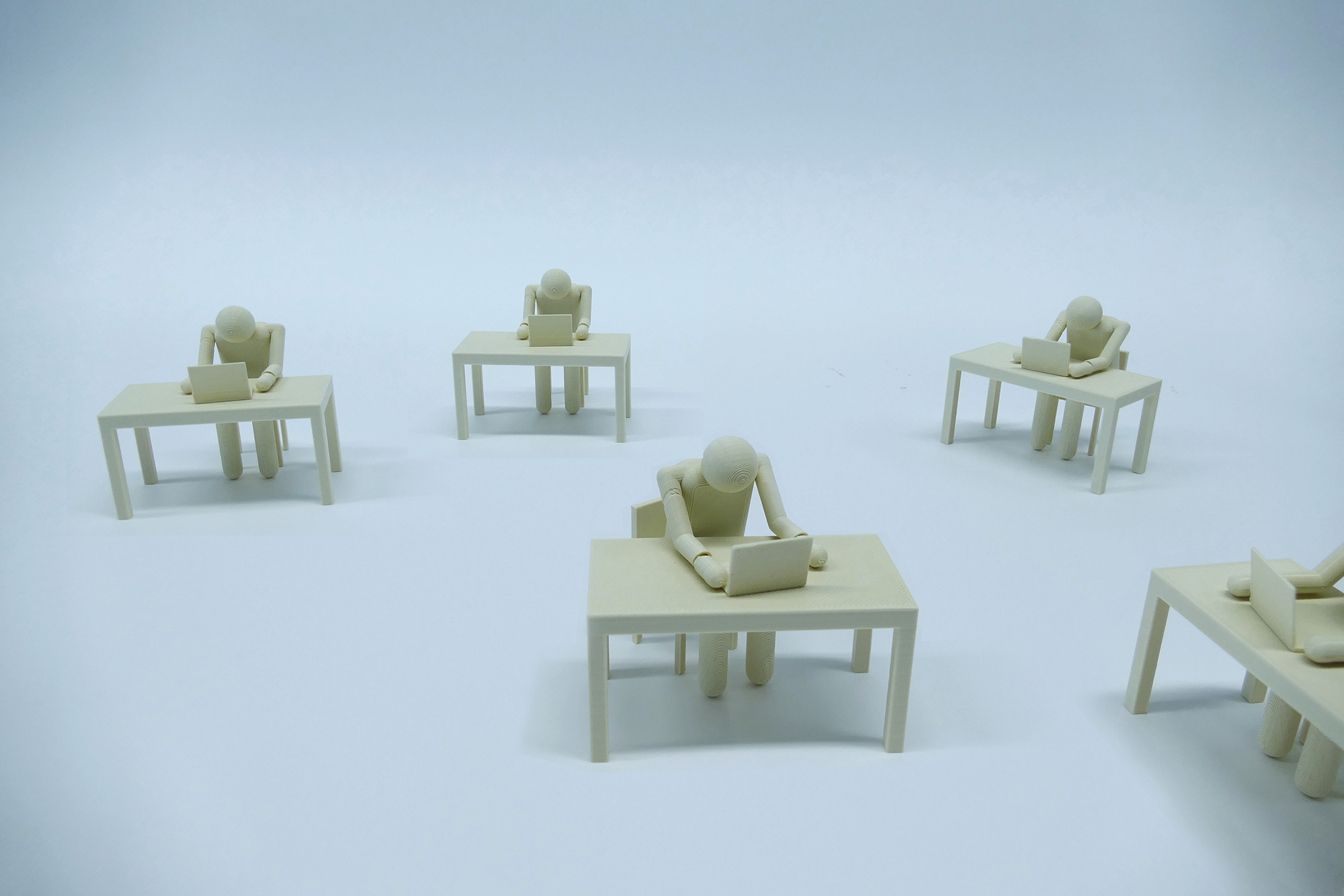 This image shows 3D-printed figures who work at a computer in an anonymous environment. They are anonymized, almost de-humanized.