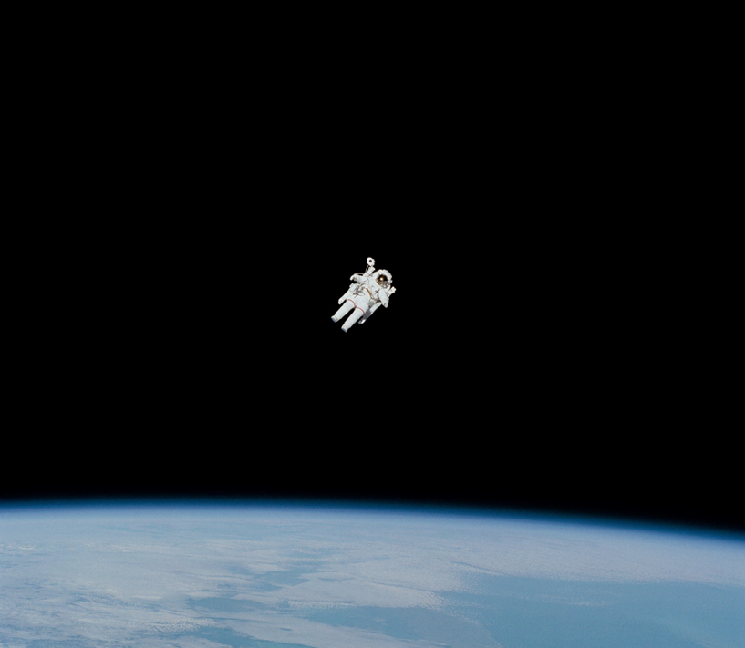 Astronaut in space suit flying free in space using a jetpack, with part of earth visible below. Image credit: NASA