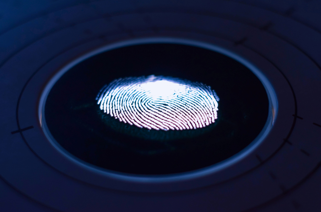 Photograph of an illuminated fingerprint on a dark background. Image credit: George Prentzas/Unsplash