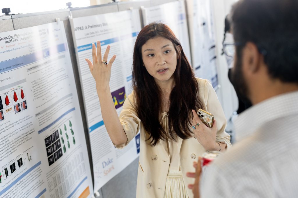Photograph of a person doing a poster presentation