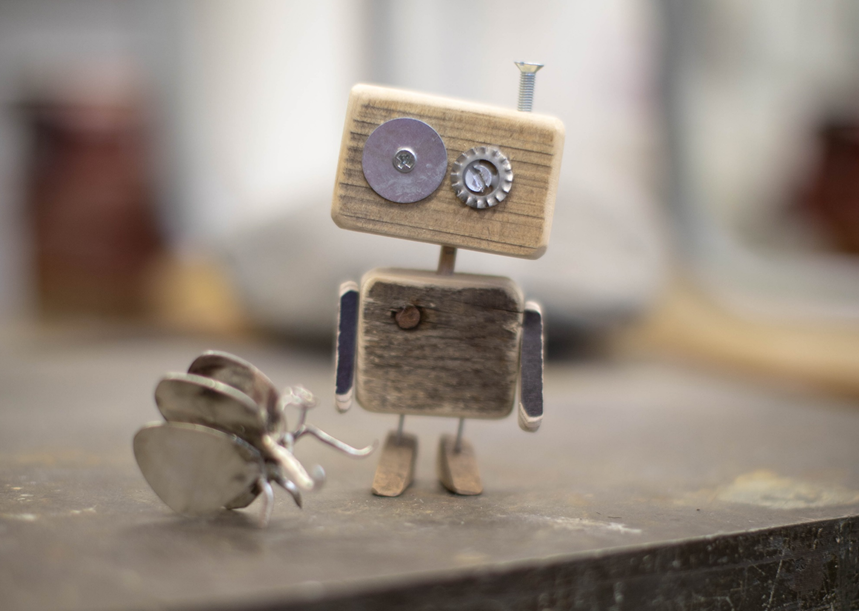 Small, off-kilter robot sculpture made out of wood, junk, and found objects. Image credit: Nina Mercado/Unsplash