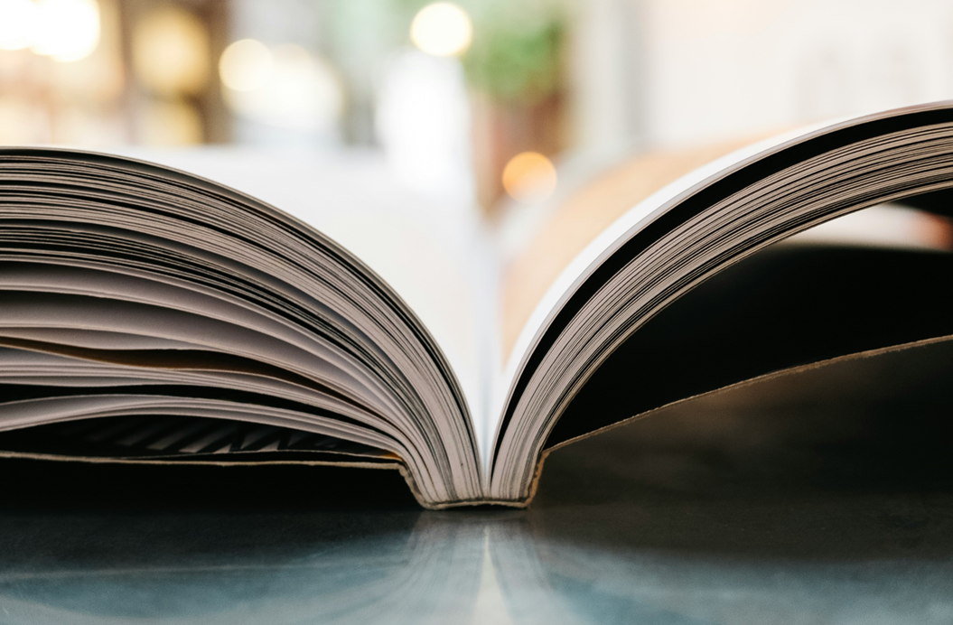 Close-up photograph of an open book, taken from top-down, perspective aligned with the book’s spine as the pages fan out. Image credit: Jonas Jacobsson/Unsplash