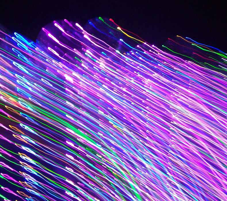 Photograph showing motion-blurred green and purple fiber optic light sources. Image credit: Yip Vick/Unsplash