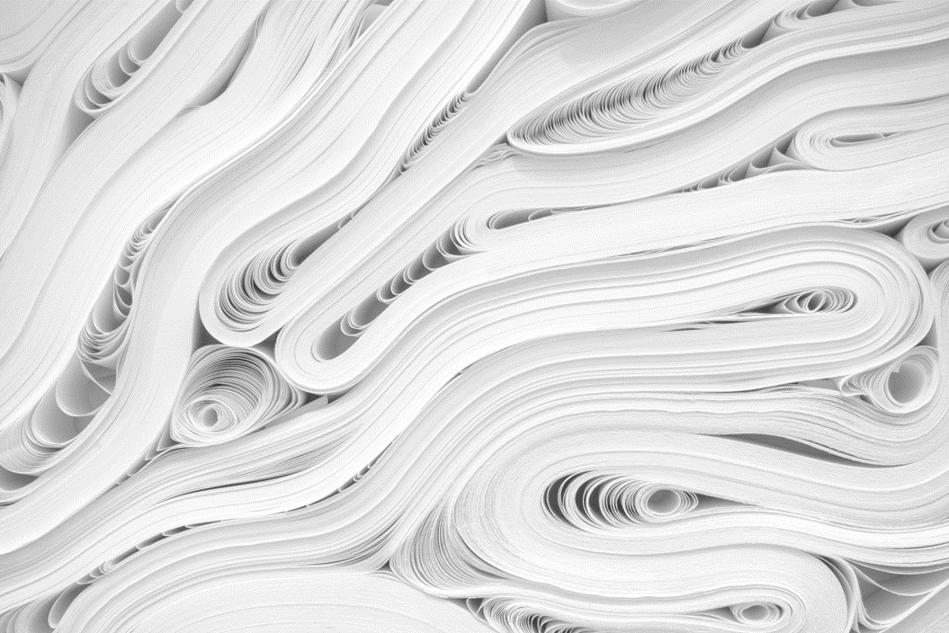 Reams of white paper in chaotic heaps and folds, viewed from edge-on. Image credit: JJ Ying/Unsplash