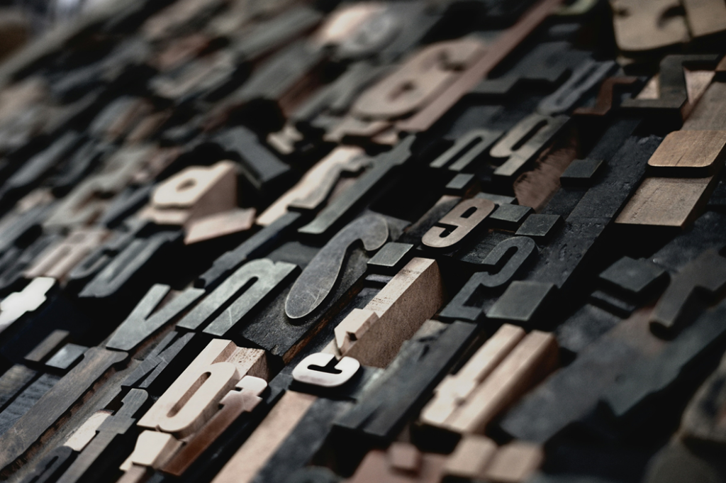 Selective focus photograph of a disorderly jumble of moveable type letters. Image credit: Raphael Schaller/Unsplash