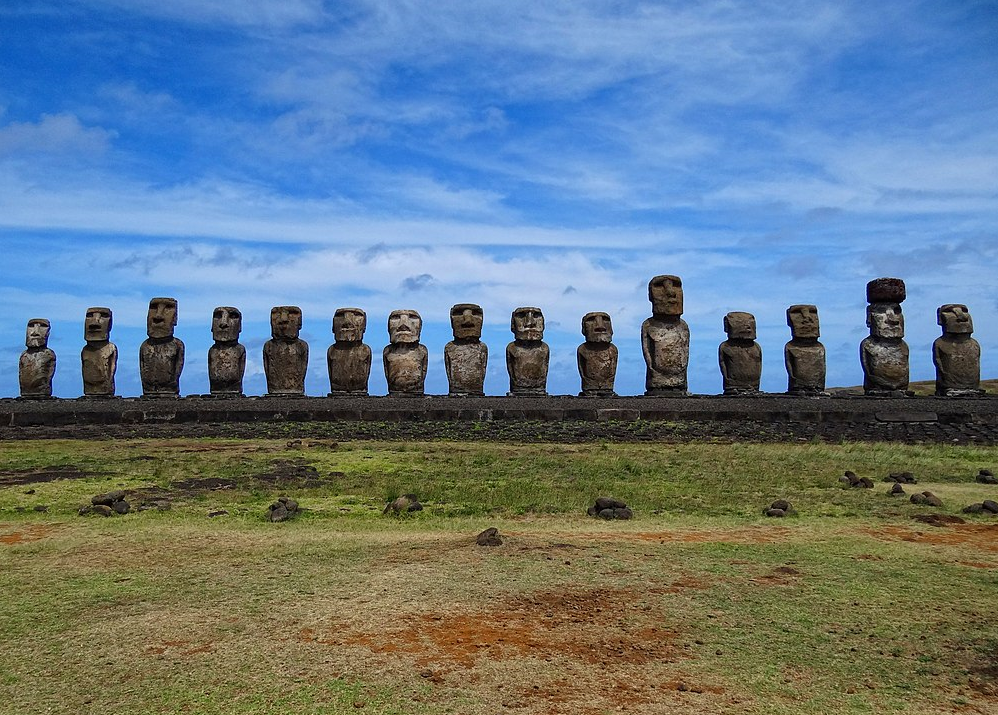 Photograph of a row of moai (giant stone statues) at Ahu Tongariki, Rapa Nui (Easter Island.) Image credit: Bjørn Christian Tørrissen via Wikimedia Commons (CC BY-SA 3.0).