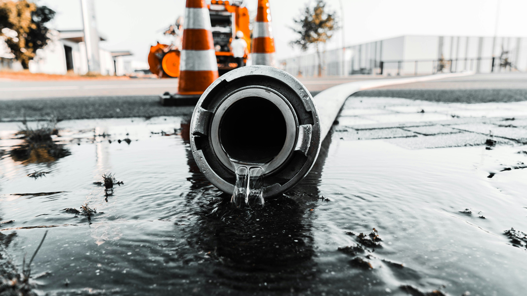 Closeup photograph of the nozzle of a firehose with a trickle of water coming out of it. Image credit: Daan Mooij/Unsplash