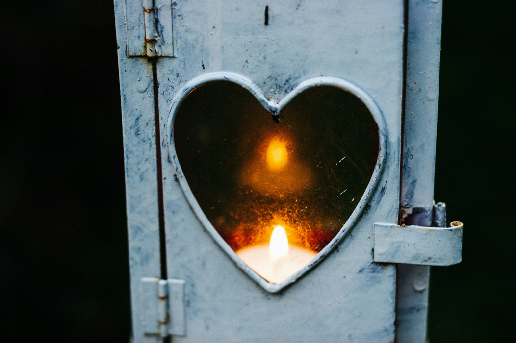 Lighted candle lantern with a heart shaped window showing the candle flame. Image credit: Cathal Mac an Bheatha/Unsplash