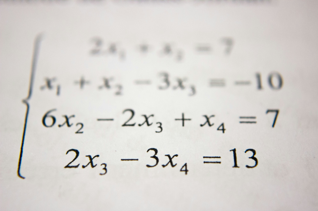 Close-up selective focus photograph of algebraic equations. Image credit: Antoine Dautry/Unsplash