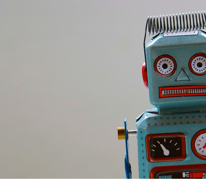 Old-fashioned toy robot made of metal. Robot is facing the viewer with wide eyes and “teeth” that appear to be grimacing. Analog gauges decorate the robot’s torso. Image credit: Rock’n Roll Monkey/Unsplash