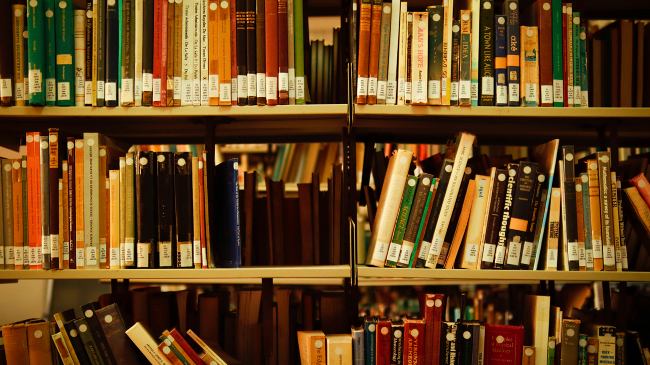 Photograph shows books shelved in an academic library. Image credit: Khaled Khazna/Unsplash
